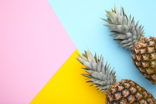 Due ananas maturi su un tavolo colorato