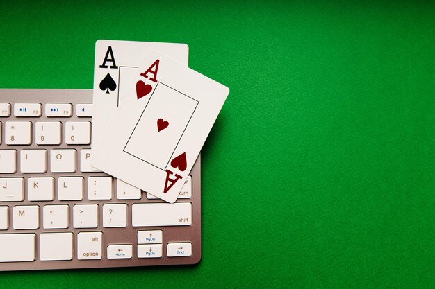 Due assi e tastiera bianca su sfondo verde Concetto di poker online