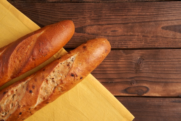 Due baguette francesi croccanti si trovano su una vecchia tavola di legno