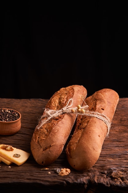 Due baguette fresche sulla tavola di legno scura. Messa a fuoco selettiva