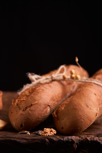 Due baguette fresche sulla tavola di legno scura.