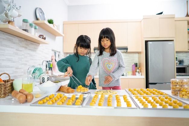 Due bambina che fa la torta crostata nastar insieme a casa cucina