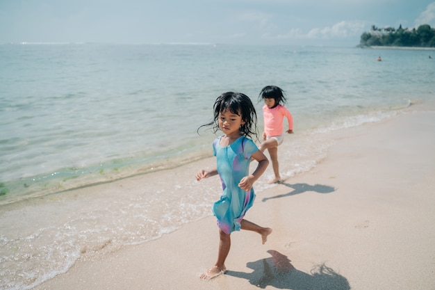 Due bambine che corrono sulla spiaggia