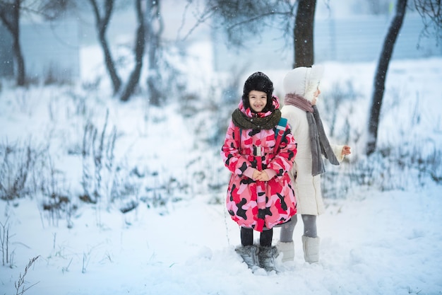 Due bambine che giocano all'aperto durante forti nevicate.