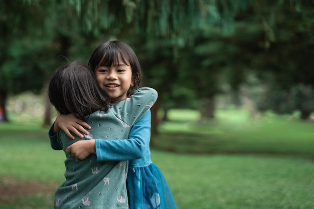 Due bambine che si abbracciano perdonano