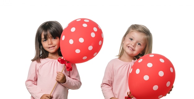 Due bambine con palloncino rosso