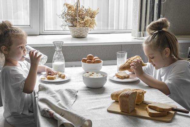 due bambine fanno colazione a casa con prodotti naturali e salutari
