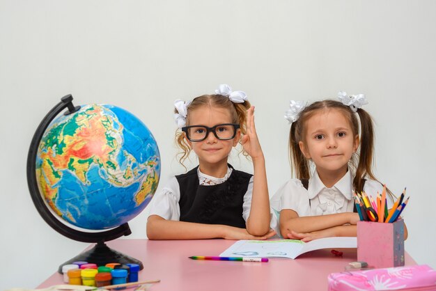 due bambine felici studiano e scrivono in classe isolare