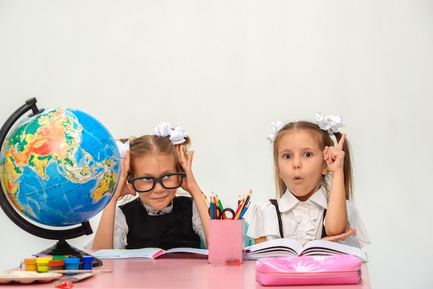 due bambine felici studiano e scrivono in classe isolare