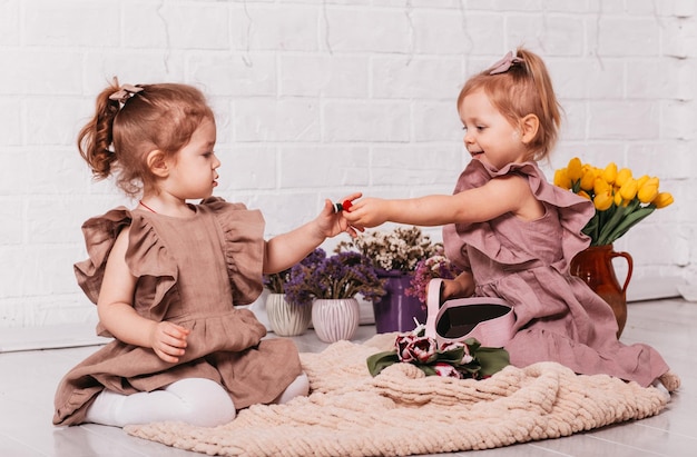 Due bambine in bellissimi abiti in studio con fiori