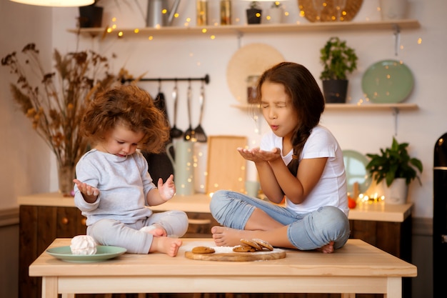 due bambine preparano i biscotti di Natale in cucina