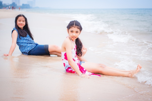 Due bambine sono sulla spiaggia.