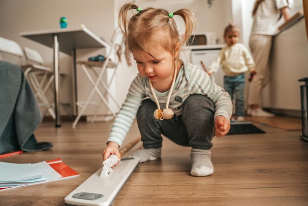 Due bambini aiutano il genitore a pulire la cucina