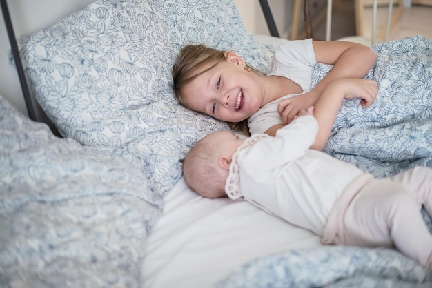 due bambini che giocano a letto