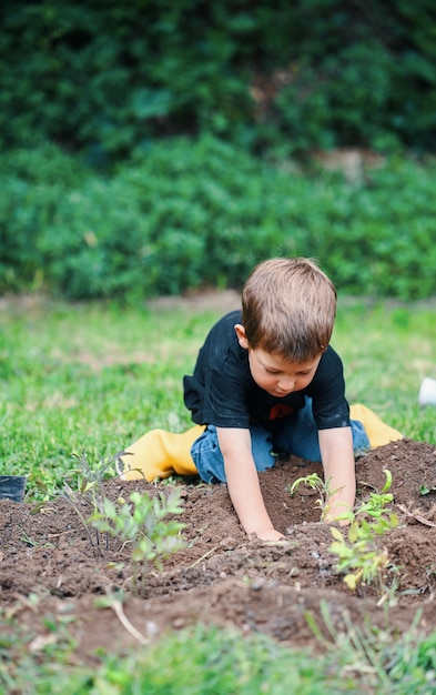 Due bambini che piantano in giardino