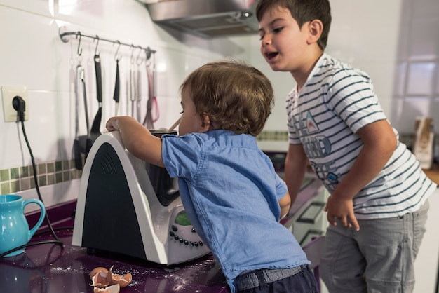 Due bambini che preparano frittelle con un robot da cucina.