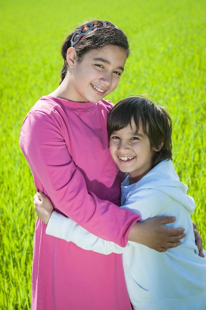 Due bambini felici nel grano verde
