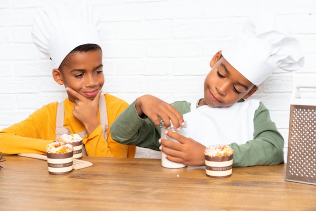 Due bambini fratelli afroamericani vestiti da chef