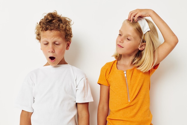 Due bambini gioiosi divertente maschera medica stanno fianco a fianco primo piano sfondo chiaro