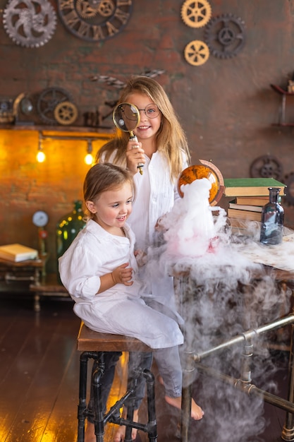 Due bambini piccoli conducono interessanti esperimenti chimici con il fumo a scuola. Formazione scolastica