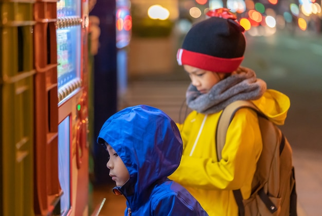 Due bambini scelgono le bevande dal distributore automatico