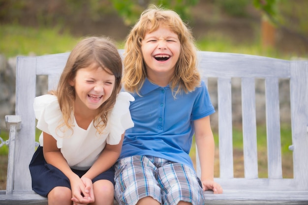 Due bambini sorridenti e ridenti che si rilassano all'aperto nel parco estivo Fratello e sorella felici che camminano nella natura Fratelli e sorelle che giocano in giardino