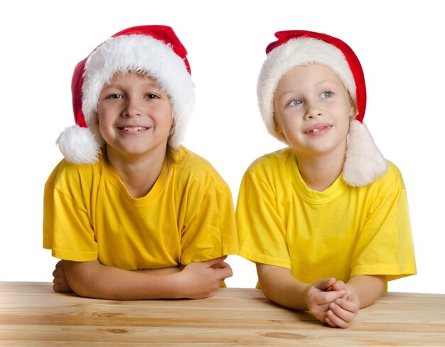 Due bambini sorridenti in cappelli di Babbo Natale