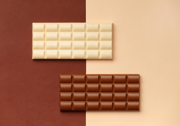 Due barrette di cioccolato su sfondo marrone e beige