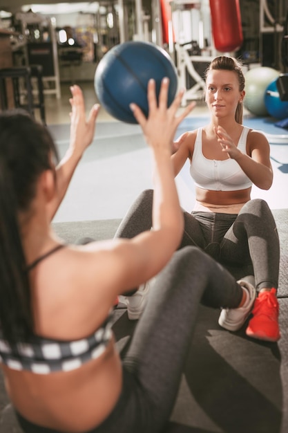 Due belle amiche che fanno sit-up in palestra.