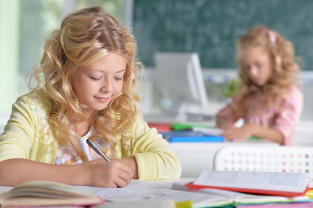 Due belle bambine che fanno i compiti in classe