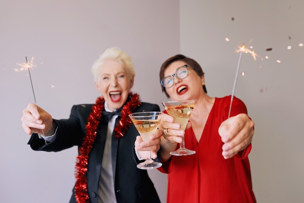 Due belle donne anziane mature alla moda che celebrano il nuovo anno