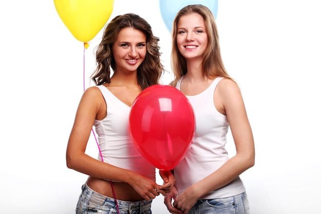 Due belle giovani amiche con palloncini colorati