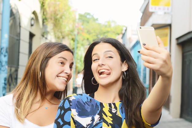 Due belle giovani donne facendo selfie e facendo smorfie