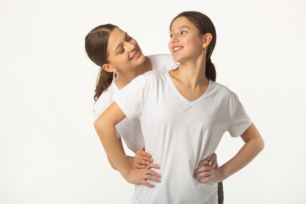 due belle giovani donne in magliette bianche su sfondo bianco