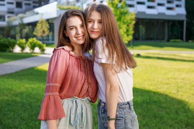 Due belle ragazze che passeggiano nel parco estivo concludono la conversazione