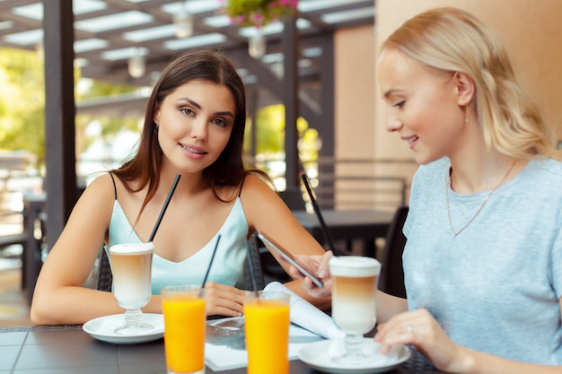 Due belle ragazze giovani seduti a tavola in caffè