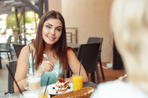 Due belle ragazze giovani seduti a tavola in caffè