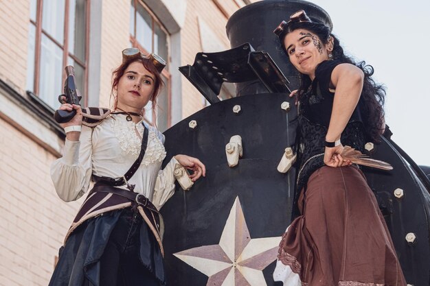 Due belle ragazze in abiti steampunk sullo sfondo del treno