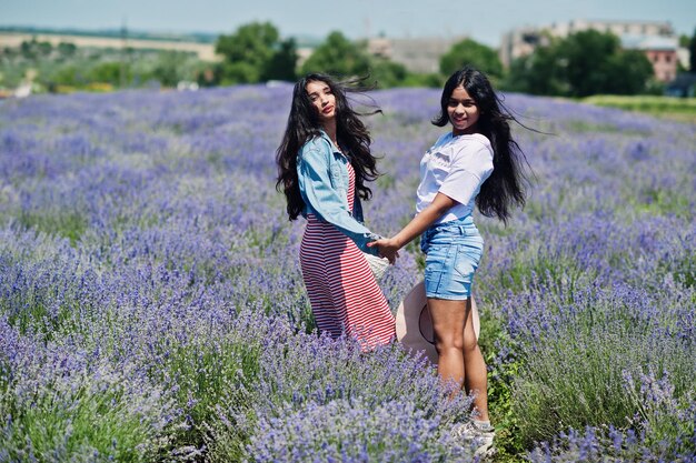 Due belle ragazze indiane nel campo viola della lavanda.