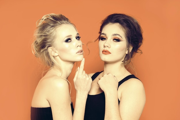 Due belle ragazze modelli in studio su uno sfondo luminoso
