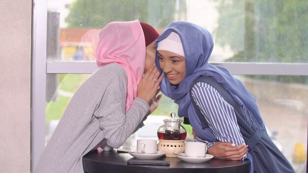 Due belle ragazze musulmane di affari in caffè.