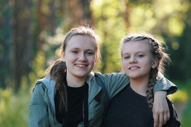 Due belle ragazze sorelle adolescenti amici nel parco - estate all'aperto, teleobiettivo shot