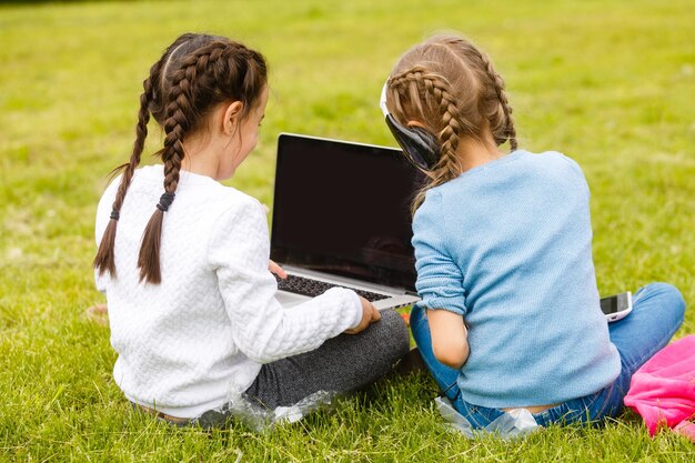 Due belle sorelle fanno i compiti durante la quarantena. I bambini usano i gadget per imparare. Istruzione, didattica a distanza, scuola a casa durante la quarantena