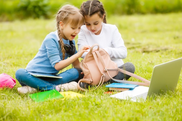 Due belle sorelle fanno i compiti durante la quarantena. I bambini usano i gadget per imparare. Istruzione, didattica a distanza, scuola a casa durante la quarantena