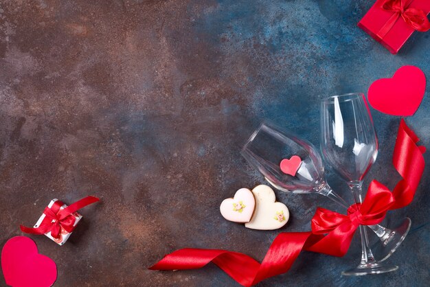 Due bicchiere di vino, cuori di biscotti su fondo di pietra. San Valentino