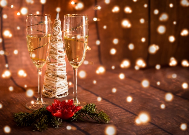 Due bicchieri con champagne e decorazioni natalizie e luci