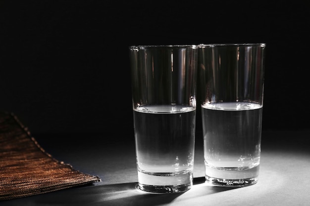 Due bicchieri di acqua pura su sfondo scuro