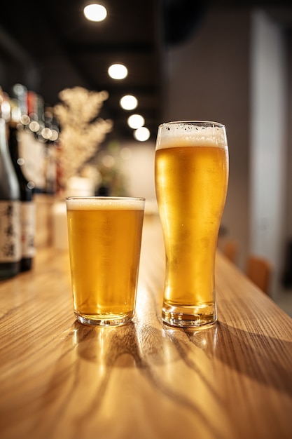 Due bicchieri di birra chiara giapponese sul bancone di un bar
