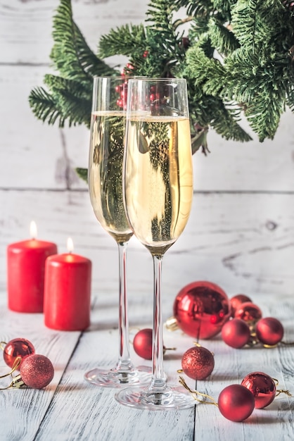 Due bicchieri di champagne con ramo di un albero di Natale