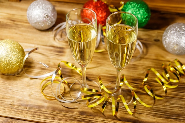 Due bicchieri di champagne e decorazioni natalizie festive su tavola di legno Festa di Natale e Capodanno